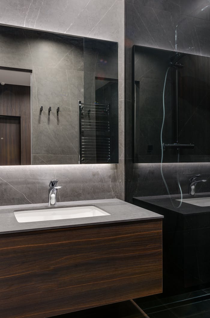 Elegant contemporary bathroom with marble surfaces and wooden vanity.