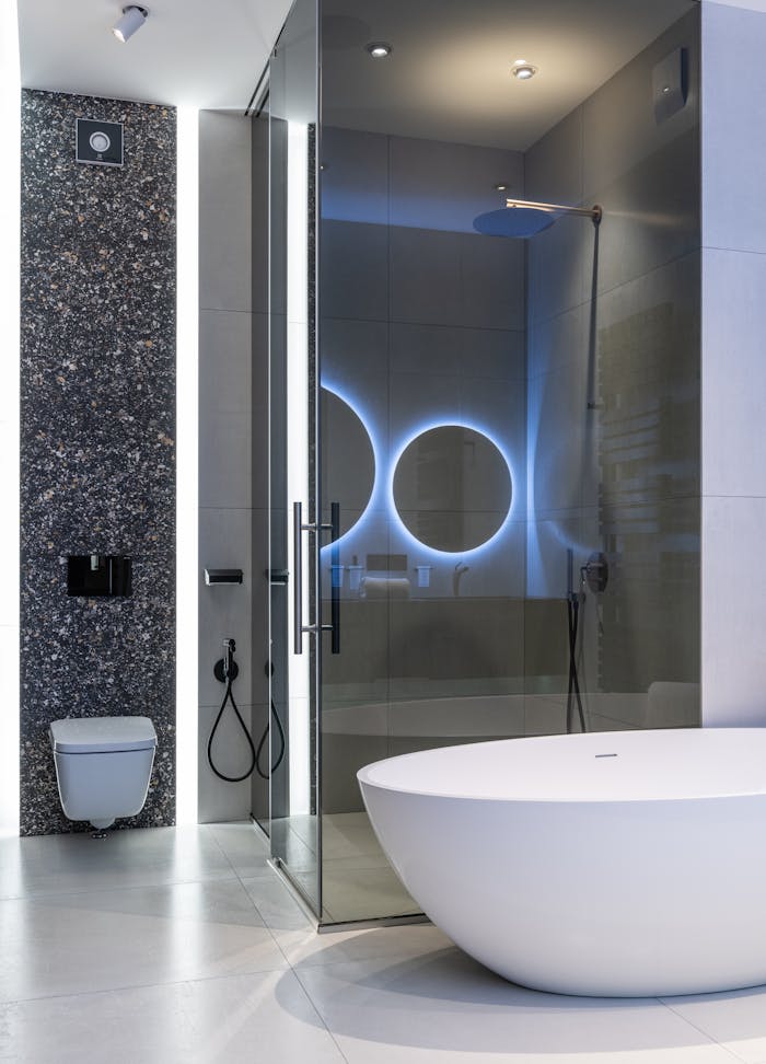 Sleek modern bathroom featuring a freestanding tub and illuminated shower area.
